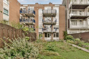 Balkonları ve yeşillikleri olan iyi bakımlı modern bir apartman kompleksi. Mimari çağdaş tasarım ilkelerini yansıtır..