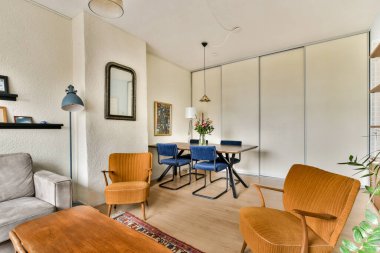 Rahat mobilyalar, sıcak renkler ve rahatlama ve sosyalleşme için davetkar bir atmosfer yaratan modern bir oturma odası..