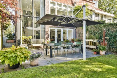 Bereketli yeşilliklerle çevrili, gölgeli bir gölgelik altında şık bir masa ve sandalyeler barındıran ferah bir avlu. Rahatlama ve toplanma için mükemmel..