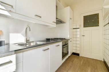 Zarif ve şık bir modern mutfak. Minimalist dolaplar, paslanmaz çelik aletler ve temiz ve düzenli bir düzen. Çağdaş yaşam için mükemmel.