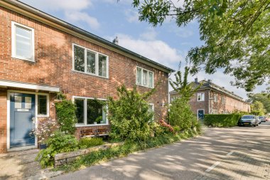 Canlı yeşil bitkiler ve ağaçlarla bezenmiş büyüleyici tuğla evler sergilenen rahat bir yerleşim alanı, sakin bir şehir ortamı yaratıyor..