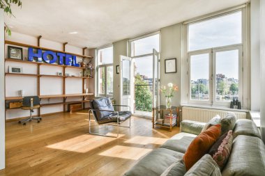 Parlak ve davetkar bir otel odası. Büyük camları, modern bir sandalyesi ve şık bir dekoru var. Rahatlamak ve rahatlamak için mükemmel..