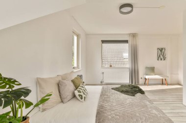 Parlak iç mekan, doğal ışığı davet eden büyük pencereler sergiliyor, modern mobilyalarla tamamlanmış sıcak ve davetkar bir atmosfer yaratıyor..