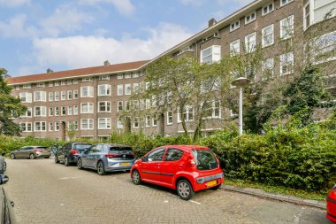 Modern konut binaları ve yemyeşil yemyeşil, şehir keşfi için mükemmel, park halindeki arabaların yer aldığı pitoresk bir şehir manzarası..
