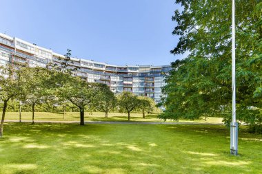 Çağdaş bir yerleşim yeri, yemyeşil ağaçlar ve çimenlerin arasına kurulur ve mimari ile doğa arasındaki dengeyi vurgular..