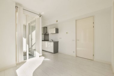 Geniş, minimumda döşenmiş bir oda modern bir mutfağa ve doğal ışığın boşluğu doldurmasına izin veren geniş pencerelere sahip. Tasarım basitliği ve zarafeti vurgular..