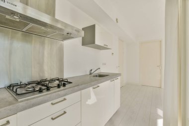 Gösterişli, çağdaş, minimalist tasarım beyaz dolaplar, paslanmaz çelik aletler ve bol miktarda doğal ışık..