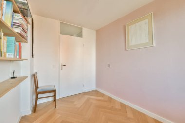 Düz bir iç mekan, ahşap döşemeli minimalist bir tasarım, basit bir sandalye, renkli bir kitaplık ve yumuşak duvar renklerinde..