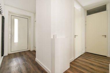 Geniş ve parlak bir iç koridor. Parlak beyaz duvarlar, modern kapılar ve ahşap döşemeler içeriyor. Çağdaş ev estetiğini geliştiriyor..