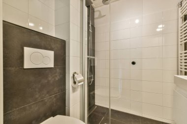 Duş, minimalist fayanslar ve konfor ve stil için tasarlanmış çağdaş eşyalar içeren gösterişli modern bir banyo..