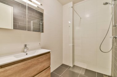 Zarif eşyalar, minimalist dolaplar ve parlak fayans tasarımları olan şık ve çağdaş bir banyo. Modern bir mekanda stil ve işlevselliğin mükemmel bir karışımı..