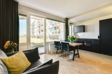 Geniş pencereli, yemek salonlu ve şık mutfak tasarımlı şık ve modern bir daire, konfor ve zarafeti ön plana çıkarıyor..