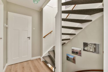 Tarafsız renkler ve minimalist dekorlarla çevrili şık bir merdiven. Mekan, zarafetle işlevselliği birleştirerek modern bir estetik tasarım sergiliyor..