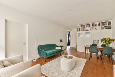 Minimalist mobilyaların, nötr tonların ve ahşap döşemelerin bulunduğu geniş bir oturma odası rahat ve davetkar bir atmosfer yaratıyor..