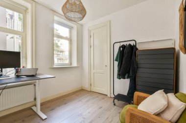 Parlak ve havadar bir minimalist ev ofisi şık bir çalışma alanı, bir pencereden gelen doğal ışık ve üretken bir atmosfer için modern mobilyalar..