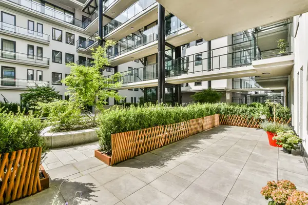 Zarif bitki düzenlemelerinin, temiz çizgilerin ve modern mimarinin bulunduğu canlı bir avlu. Doğayla şehir yaşamının mükemmel bir karışımı..