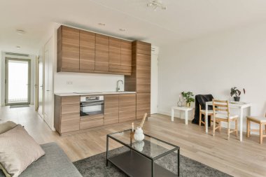 Şık, modern bir iç mekan. Mutfak ve yaşam alanı. Gösterişli dolaplar, minimalist mobilyalar ve doğal ışık. Tasarım rahatlığı ve basitliği vurguluyor..