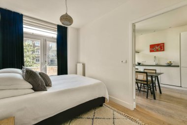 Güzel tasarlanmış, modern dekorlu, davetkar atmosferi olan, pencerelerden süzülen doğal ışıkla güçlendirilmiş bir oda..