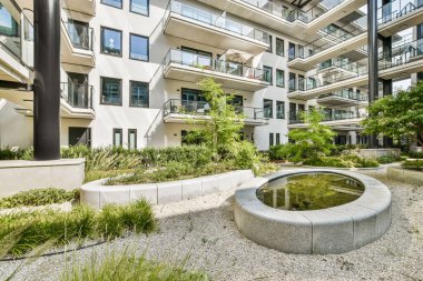 Çağdaş bir konut avlusu yeşillik, su özellikleri ve şık apartman balkonları ile kentsel yaşam estetiğini geliştirir.