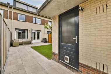 Temiz giriş kapısı, veranda alanı ve yeşil çimenli, açık hava rahatlığı ve toplanma için mükemmel bir arka bahçesi olan modern bir bahçe..