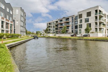 Çağdaş konut binaları sakin bir kanal oluşturarak kentsel bir ortamda doğa ve mimarinin uyumlu bir karışımını sergiliyor..