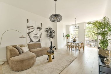 Modern mobilyaların, bol doğal ışığın ve yeşilliğin bulunduğu şık bir oturma odası, taze ve davetkar bir atmosfer yaratıyor..