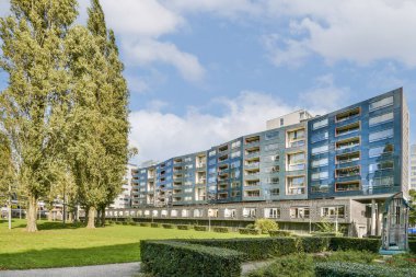 Çağdaş bir yerleşim yeri, yemyeşil manzaralar ve uzun ağaçlar arasında, doğa ve kentsel yaşamın bir karışımını sergiliyor..