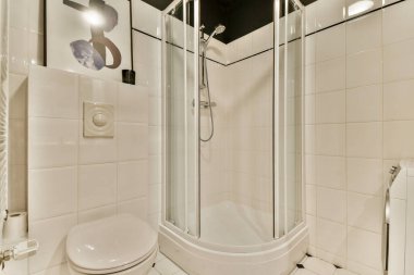 Pürüzsüz ve minimalist bir banyo. Yuvarlak bir duş. Çağdaş stil siyah beyaz fayanslar ve yeni bir görünüm için zarif eşyalar içerir..