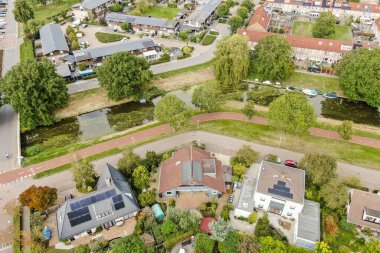 Etrafı yemyeşil ve yaya yollarıyla çevrili sakin bir su yolu boyunca sergilenen yerleşim yerleri..