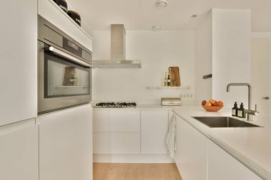 Beyaz dolaplı, entegre aletli ve temiz çizgileri olan gösterişli ve modern bir mutfak tasarımı. Çağdaş boşluklar için mükemmel.
