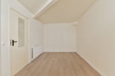 Sade beyaz duvarları ve ahşap döşemeleri olan, sadeliği ve temizliği vurgulayan sakin bir atmosfer yaratan minimalist bir iç mekan..