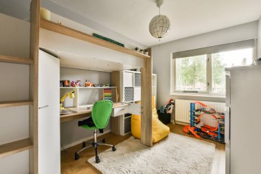 Ergonomik mobilyalar, parlak renkler ve yaratıcı öğrenme ve oyun oynamak için ideal, organize çalışma alanı içeren şık ve modern bir çocuk çalışma odası..
