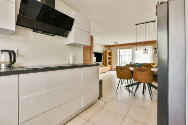 Geniş bir mutfak, gösterişli bir dolap, modern aletler ve rahat bir yemek alanı. Açık düzen ev ortamında işlevselliği ve biçimi artırır.