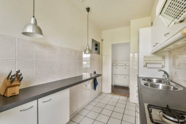 Gösterişli dolaplar, modern aletler ve yemek ve yemek pişirmek için davet edici, fonksiyonel bir alan yaratan minimalist dekorun yer aldığı çağdaş bir mutfak..
