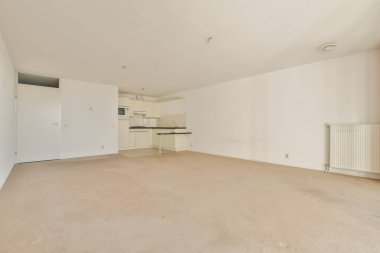 Geniş, modern oturma odası bej halı, beyaz duvarlar ve minimalist tasarım. Ev dekorasyonu veya iç dekorasyon için ideal.