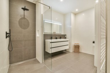 Çağdaş banyo, parlak duş alanı, minimalist eşyalar, ve zarif ve işlevsel bir yer için şık bir dolap..