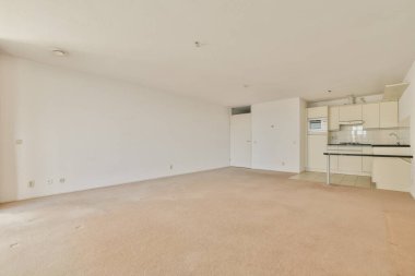Tarafsız renk paleti olan geniş, boş, modern bir daire, bej halılı döşeme ve minimalist mutfak tasarımı, özelleştirme için mükemmel..