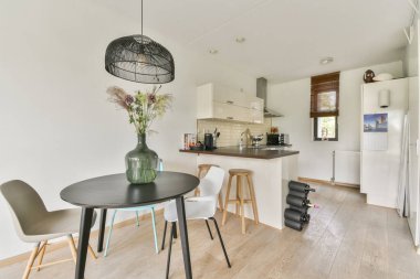 Yemek salonu, zarif mobilyalar ve minimalist dekorlarla donatılmış modern bir mutfak. Hem yemek pişirmek hem de misafir ağırlamak için mükemmel..