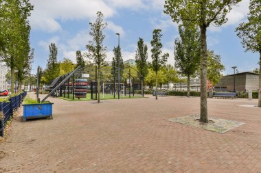 Çocuk parkı ekipmanları, ağaçlar ve kaldırımlı bir yol içeren iyi korunmuş bir şehir parkı. Şehir ortamında rahatlama ve dinlenme için mükemmel bir yer..