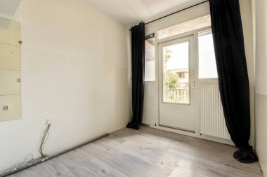 Parlak ve minimalist bir iç mekan. Geniş bir pencere, açık ahşap döşeme ve katıksız perdeler. Doğal ışık için mükemmel..