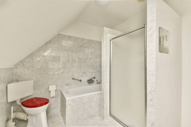 İçinde mermer duvarlar, küvet, duş ve modern tuvalet tasarımı olan şık bir banyo. Çağdaş ev dekorasyonu için mükemmel..