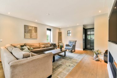 Güzel tasarlanmış, rahat bir kanepe, zarif bir dekor ve sıcak bir aydınlatma ile rahatlamak için davetkar bir atmosfer yaratan modern bir oturma odası..