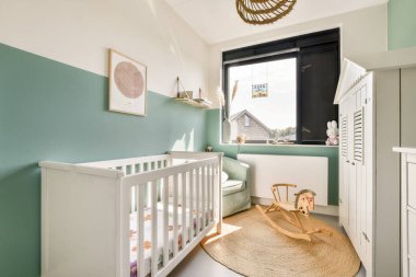 Beşik, minimalist dekor ve yumuşak renk paleti içeren şık bir kreş bebekler için rahat ve huzurlu bir yer sağlar..