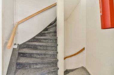 Modern bir iç mekanda şık bir spiral merdiven. Şık çizgiler ve minimalist estetik çizgilerle bir tasarım ve işlevsellik karışımı sergiliyor..