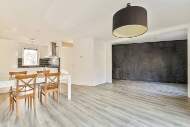 Parlak ve açık modern bir mutfak, minimalist dekorlu parlak bir tasarıma sahiptir. Yemek alanında basit bir masa ve sandalyeler var. Dağınık olmayan estetiği güçlendiriyor..