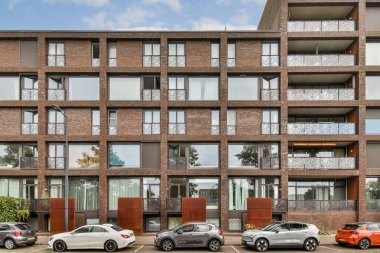 Modern kentsel mimari eğilimleri yansıtan, sayısız balkon ve geniş pencereli şık bir cephe içeren çağdaş tasarım..