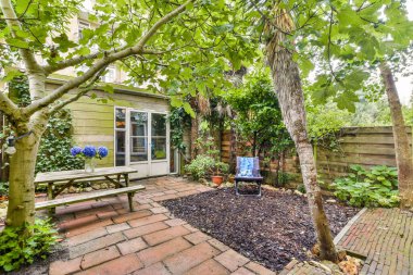 Bereketli yeşilliklerle çevrili rahat bir oturma alanı olan sakin bir bahçe sahnesi rahatlama ve farkındalık için mükemmel bir yer yaratıyor..