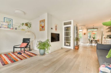 Modern mobilyaların sergilendiği şık bir oturma odası, sıcak ahşap döşemeler, ve rahat bir atmosfer, rahatlama ve toplanma için mükemmel..