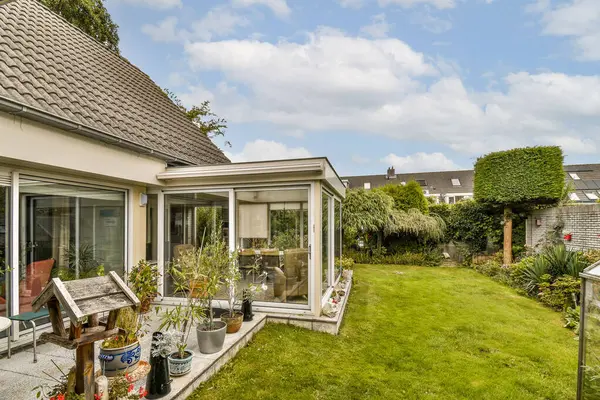 Canlı bir bahçeyle kusursuz bir şekilde harmanlanmış çağdaş cam bir yapı. Bereketli yeşillik, dekoratif bitkiler ve davetkar bir açık alan huzurlu bir atmosfer yaratır..