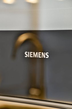 Siemens logosuna odaklan ve modern bir cihaza odaklan, marka ile ilişkili zarif tasarım ve kaliteyi vurgula.